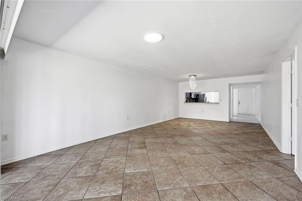 1231 Commonwealth Circle, Unit Q104 Naples, FL 34116 - Photo 12 of 33 a view of empty room with wooden floor and window