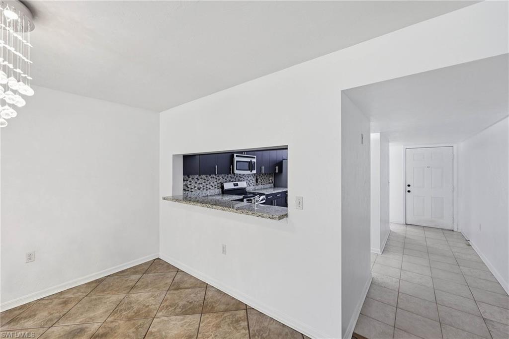 1231 Commonwealth Circle, Unit Q104 Naples, FL 34116 - Photo 13 of 33 a view of a kitchen with a sink and a refrigerator