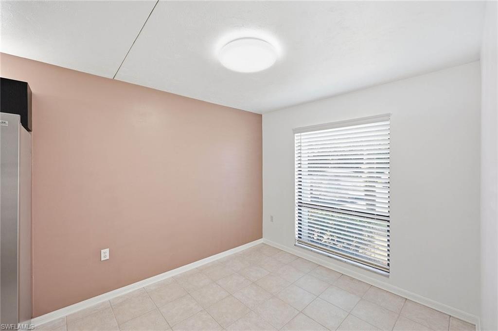 1231 Commonwealth Circle, Unit Q104 Naples, FL 34116 - Photo 16 of 33 an empty room with a window and a fan