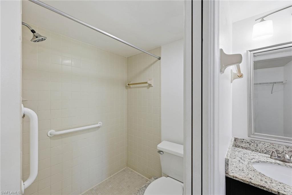 1231 Commonwealth Circle, Unit Q104 Naples, FL 34116 - Photo 24 of 33 a bathroom with a granite countertop sink toilet and shower