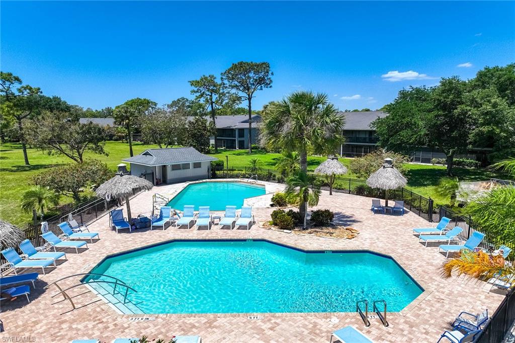 1231 Commonwealth Circle, Unit Q104 Naples, FL 34116 - Photo 31 of 33 a view of a swimming pool and lounge chairs