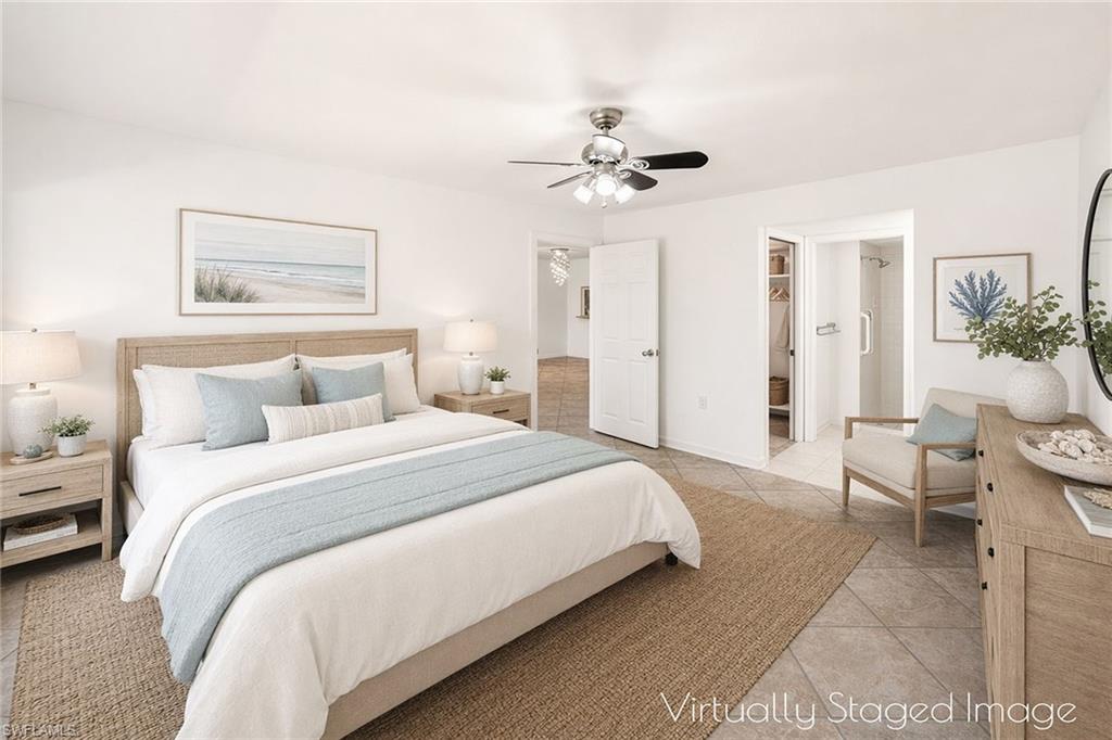 1231 Commonwealth Circle, Unit Q104 Naples, FL 34116 - Photo 5 of 33 a bedroom with a bed and a chandelier