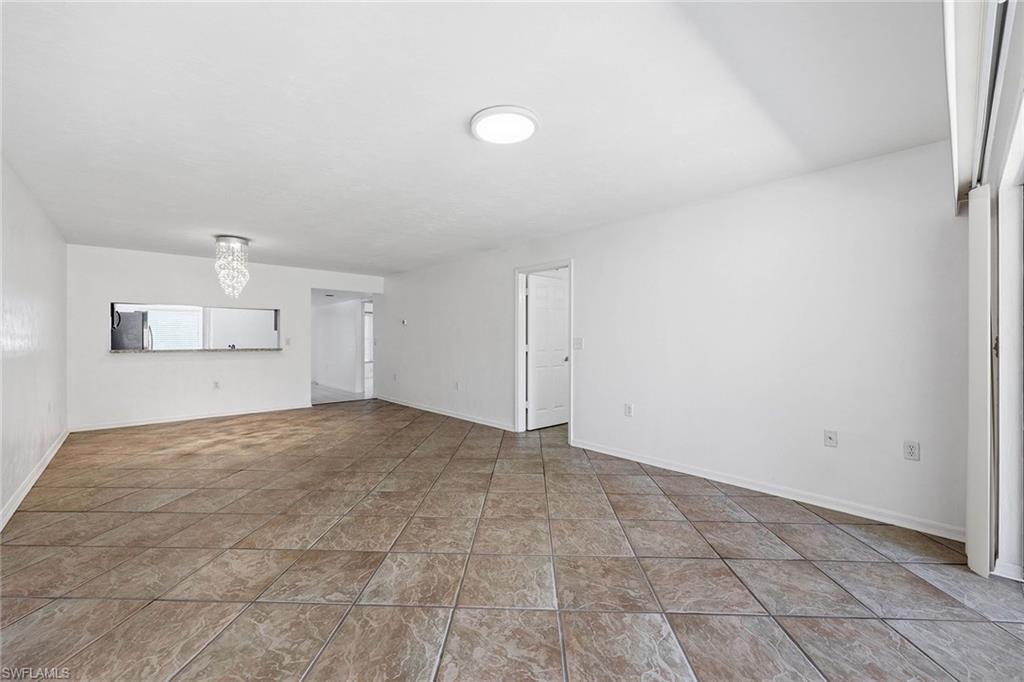 1231 Commonwealth Circle, Unit Q104 Naples, FL 34116 - Photo 8 of 33 a view of empty room with wooden floor and window