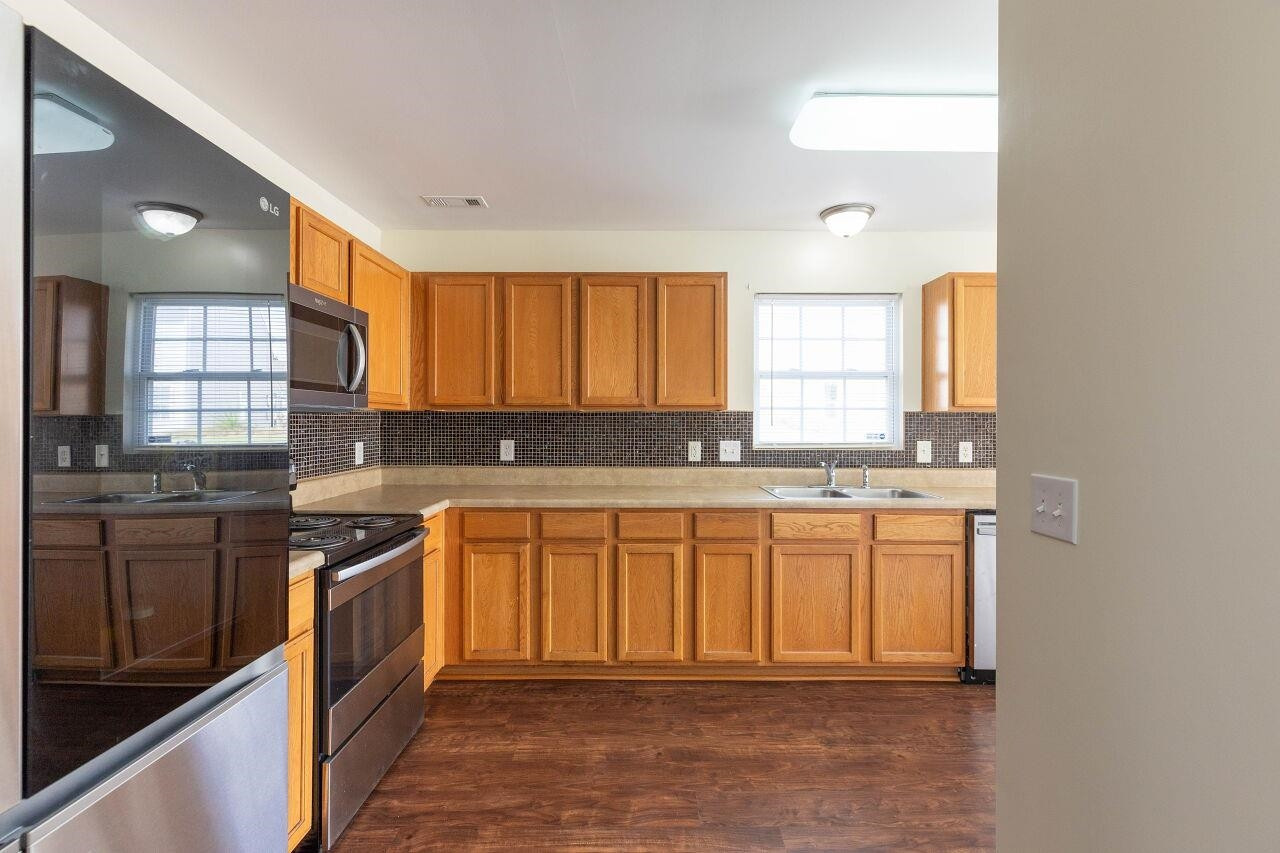 3409 Colossae Court Raleigh, NC 27610 - Photo 13 of 28 a kitchen with stainless steel appliances granite countertop a stove a sink and a microwave