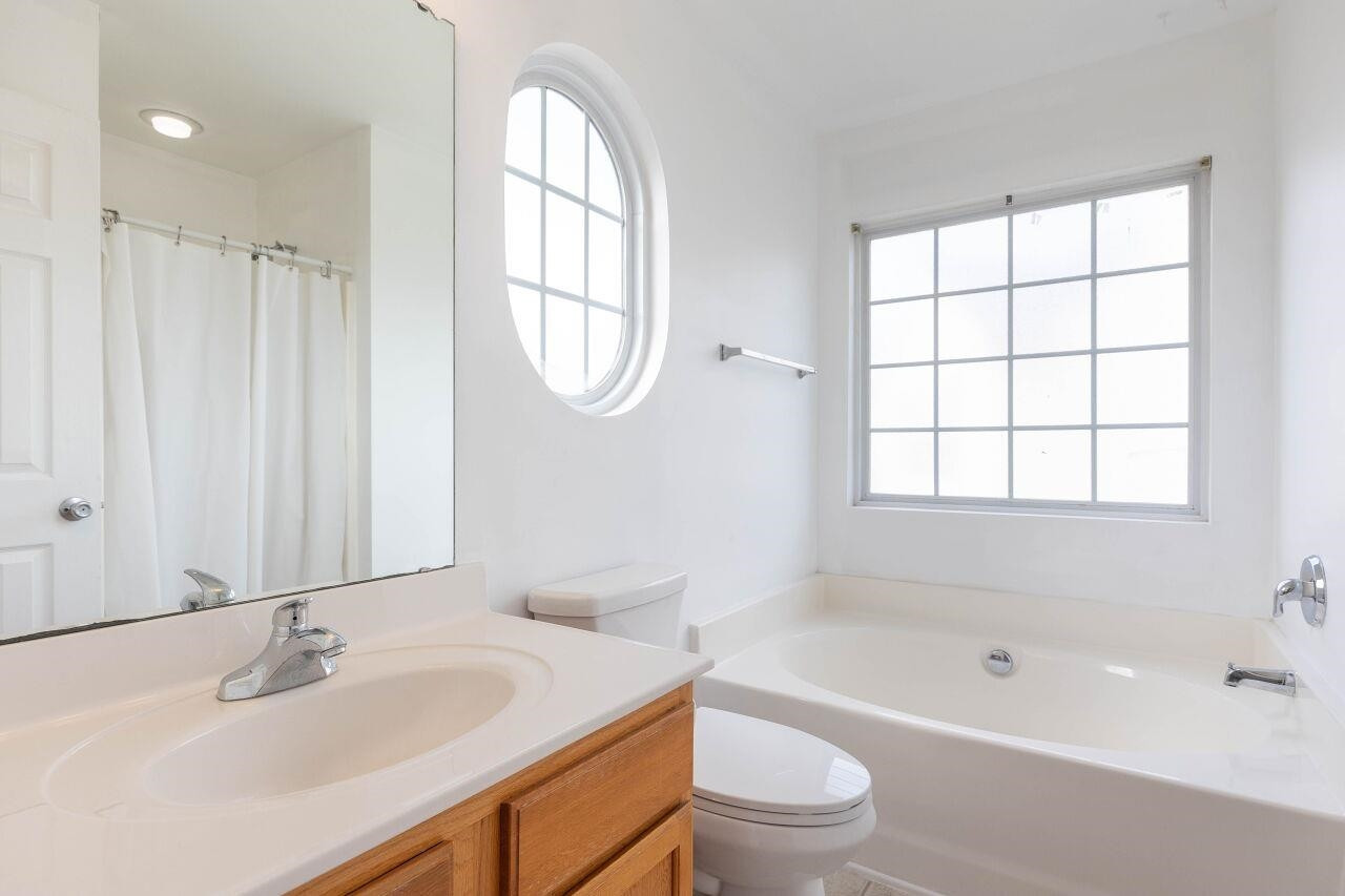 3409 Colossae Court Raleigh, NC 27610 - Photo 18 of 28 a bathroom with a bathtub a sink a toilet and a window