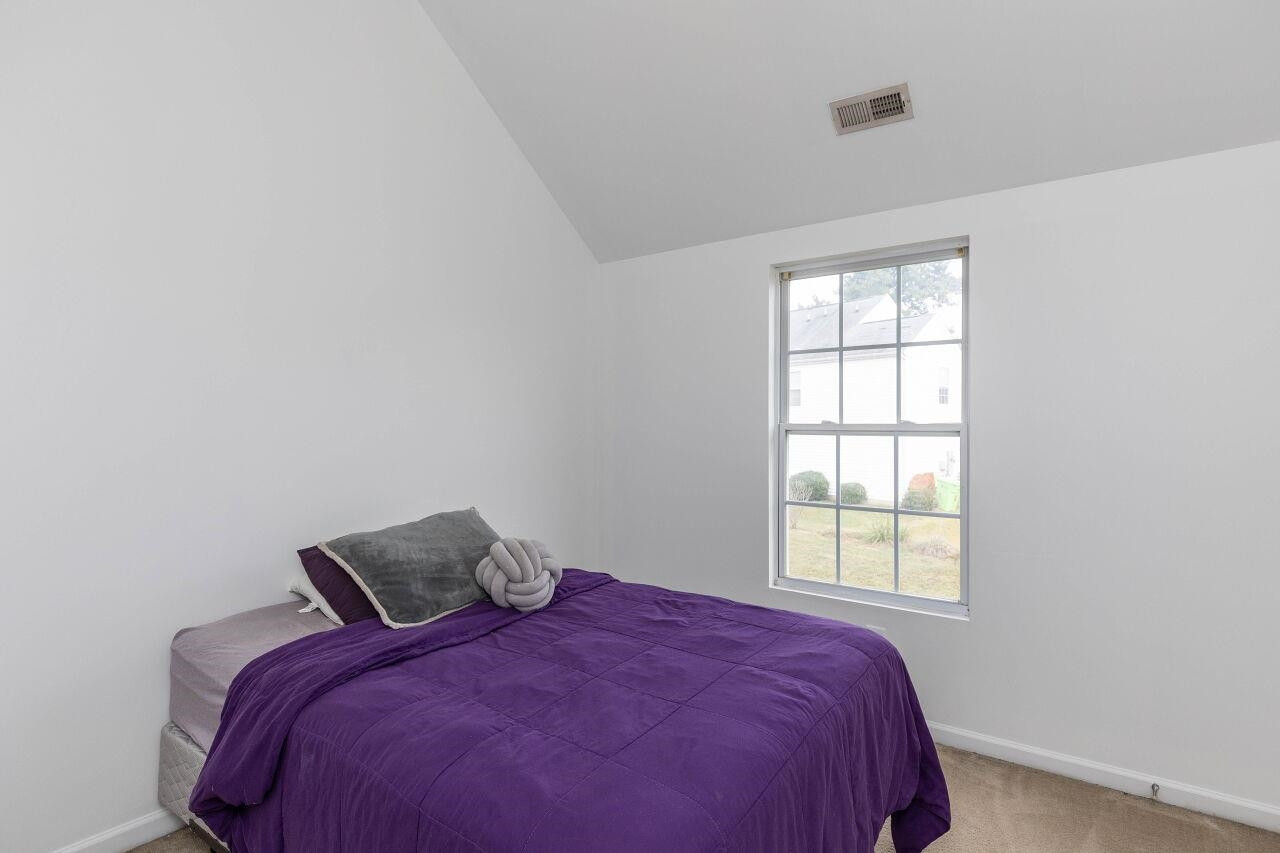 3409 Colossae Court Raleigh, NC 27610 - Photo 20 of 28 a bed sitting in a bedroom next to a window