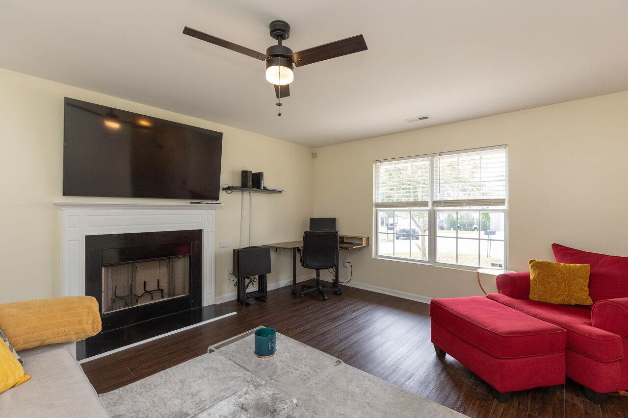 3409 Colossae Court Raleigh, NC 27610 - Photo 6 of 28 a living room with furniture a flat screen tv and a fireplace
