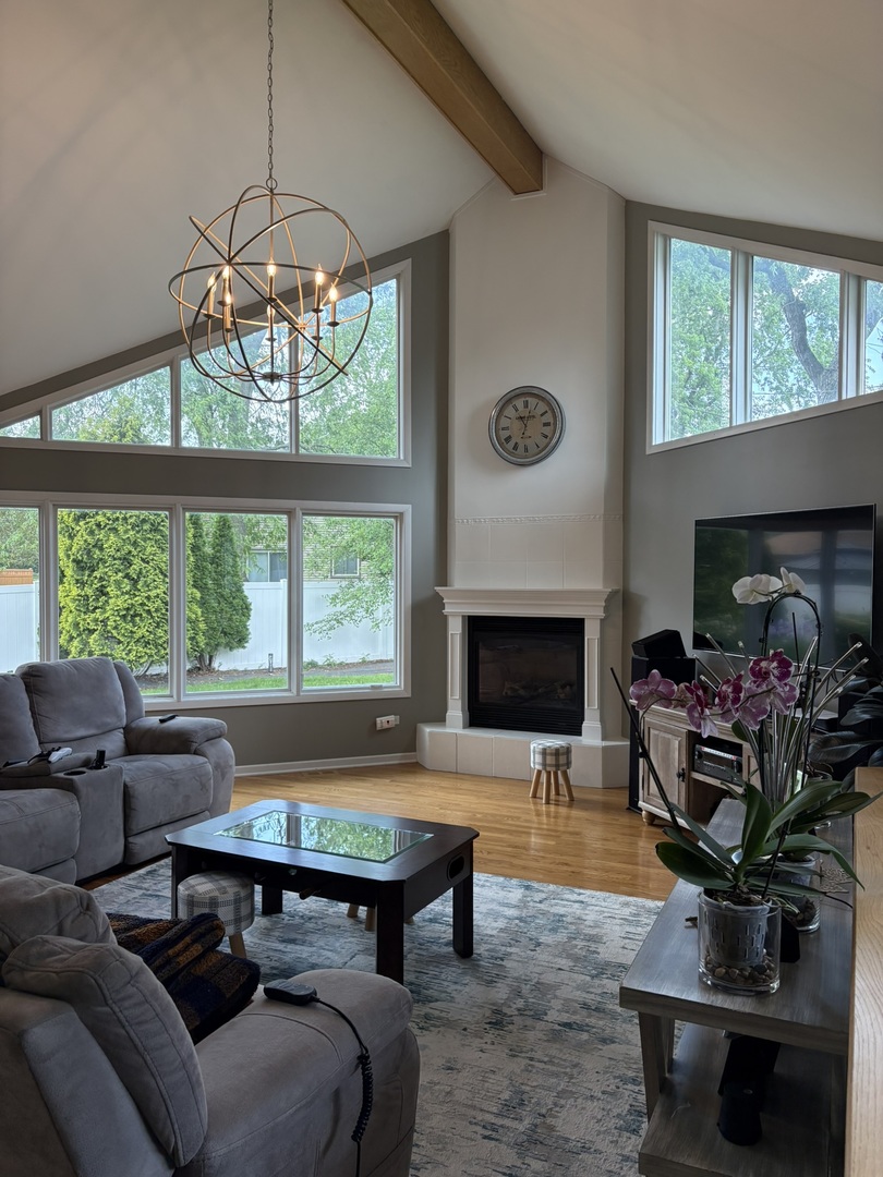 609 West Gartner Road Naperville, IL 60540 - Photo 4 of 23 a living room with furniture a chandelier and a fireplace