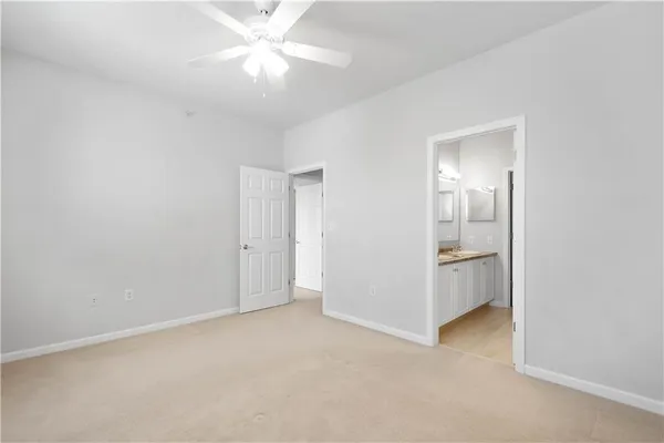 a view of a room with a ceiling fan and a bathroom
