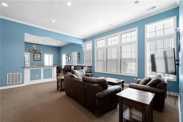 a room with stainless steel appliances kitchen island granite countertop a sink and cabinets