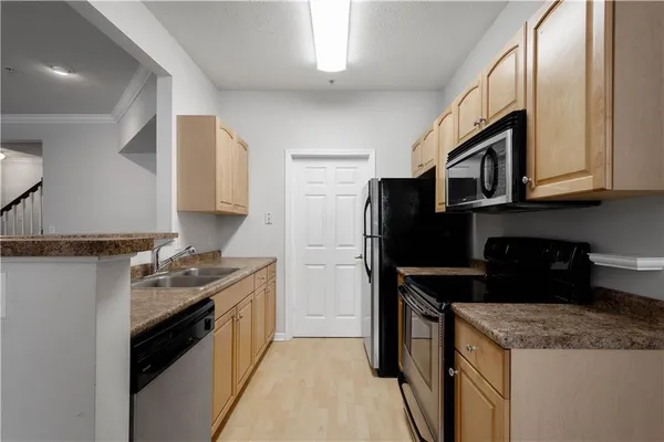 a kitchen with stainless steel appliances granite countertop a stove microwave and sink