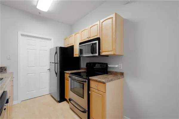 a kitchen with stainless steel appliances a refrigerator stove and microwave