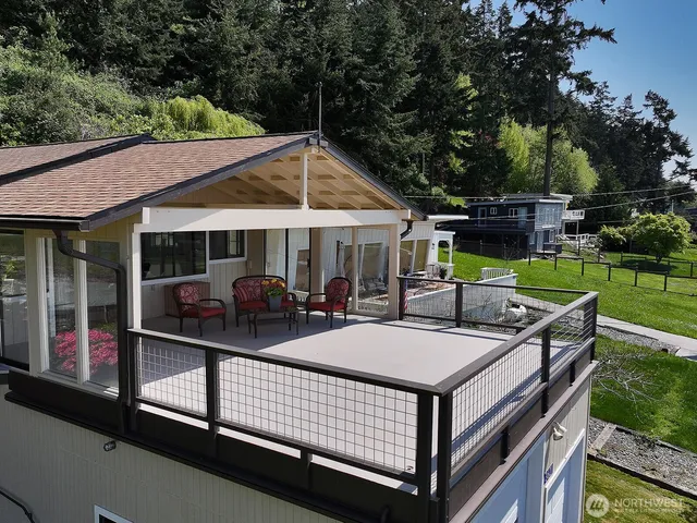 a view of a patio with couches table and chairs under an umbrella