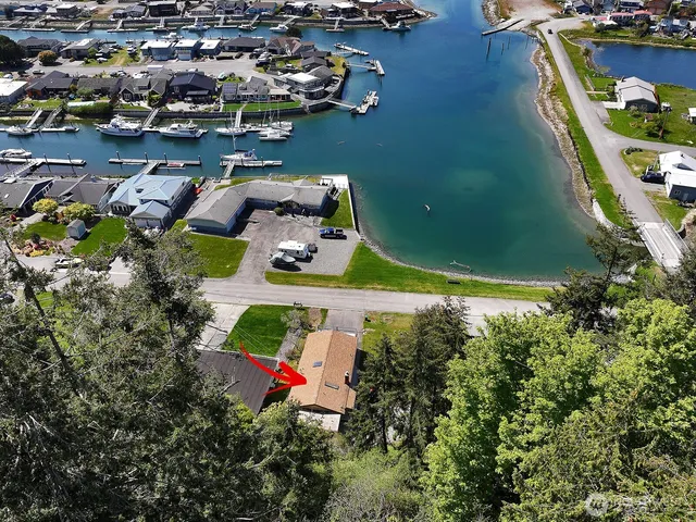 an aerial view of a house with a yard and lake view