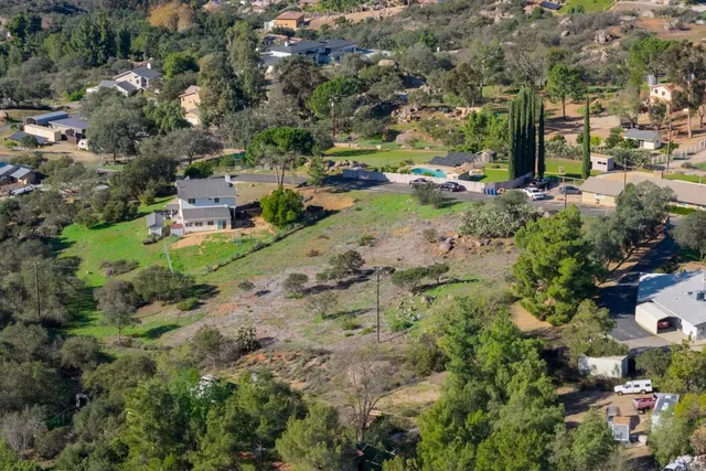 an aerial view of residential house with outdoor space and trees all around