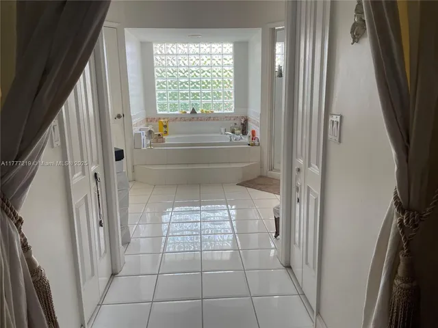 a bathroom with a bathtub and next to a window
