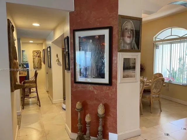 a view of a hallway with wooden floor and a living room