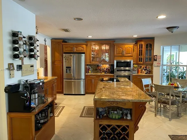 a large kitchen with stainless steel appliances granite countertop a stove and a refrigerator