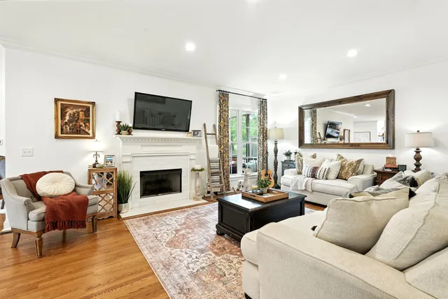 a dining room with furniture a potted plant and wooden floor