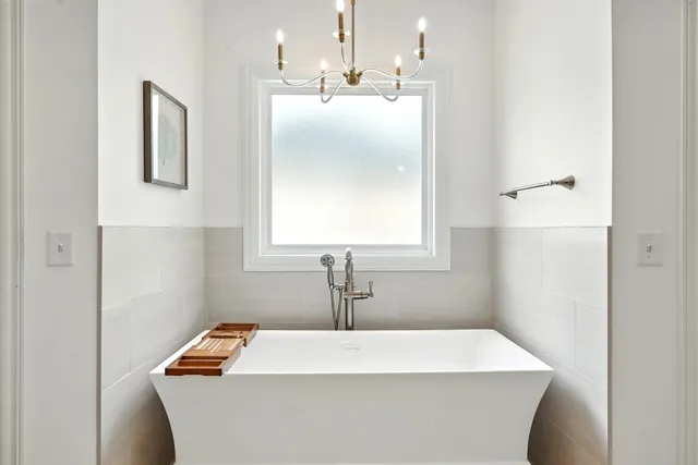 a living room with furniture a chandelier and a window