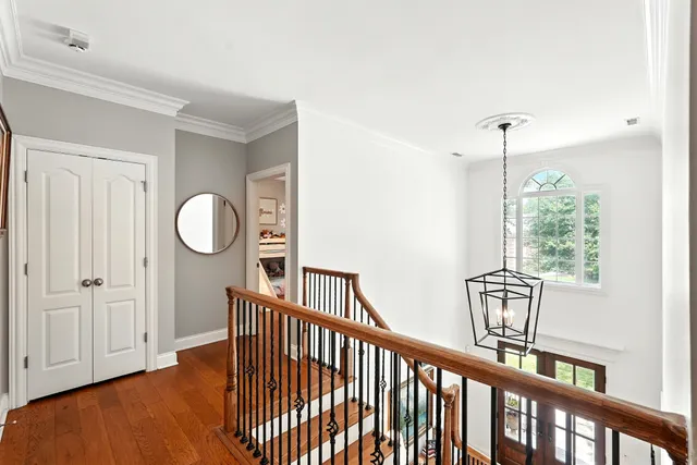 a living room with furniture a mirror and a wooden floor
