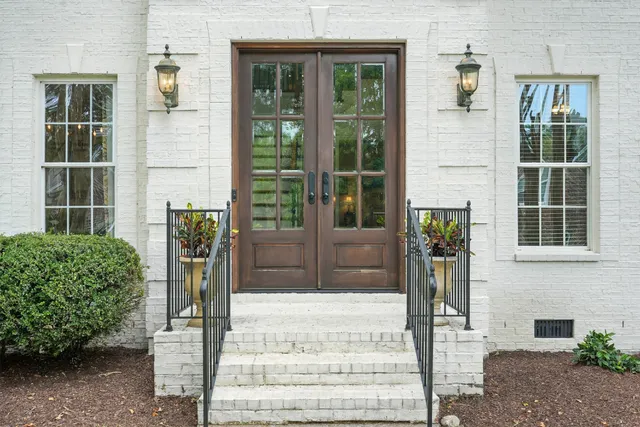 a front view of a building with a garden and plants