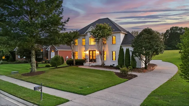 a aerial view of a house with a yard and large tree