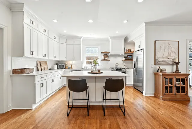 a kitchen with stainless steel appliances granite countertop a white cabinets and wooden floor