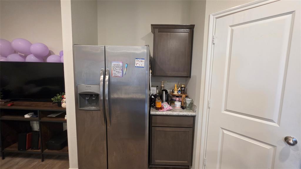409 Samuel Street Denton, TX 76207 - Photo 24 of 40 a kitchen with a refrigerator and a television