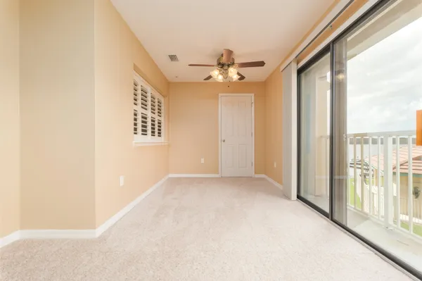a view of a big room with windows and chandelier fan