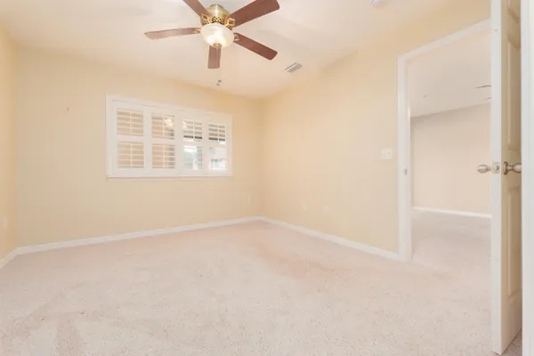 an empty room with windows and fan