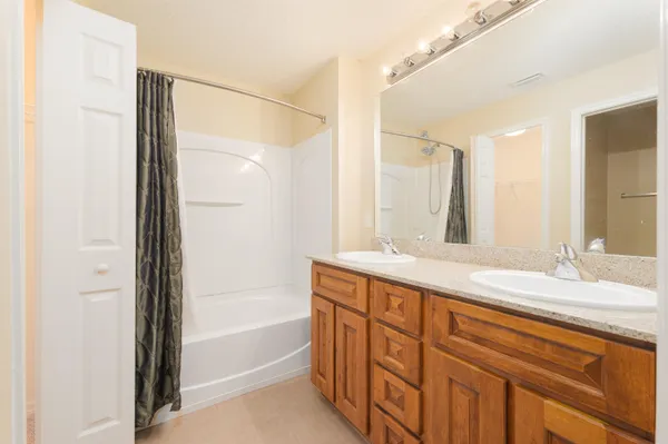 a bathroom with a granite countertop sink a mirror and a bathtub