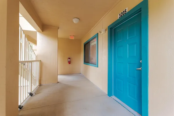 a view of a hallway with wooden floor and windows