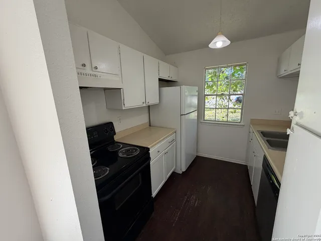 a kitchen with granite countertop a stove a sink and a microwave