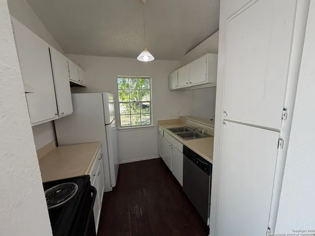 a kitchen with a sink a refrigerator a stove a microwave and cabinets