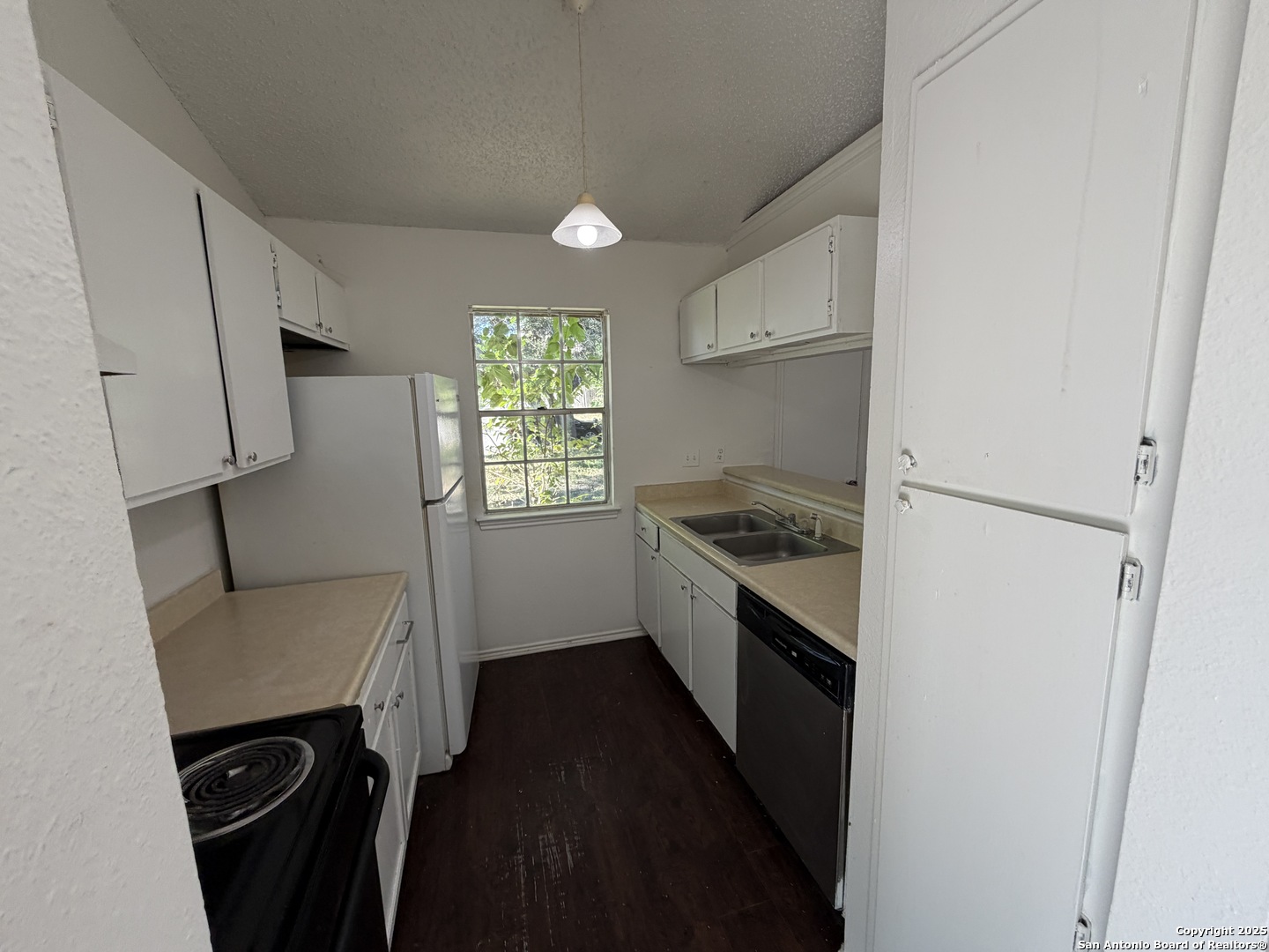 12200 Ridge Crown Street San Antonio, TX 78247 - Photo 12 of 20 a kitchen with a sink a refrigerator a stove a microwave and cabinets