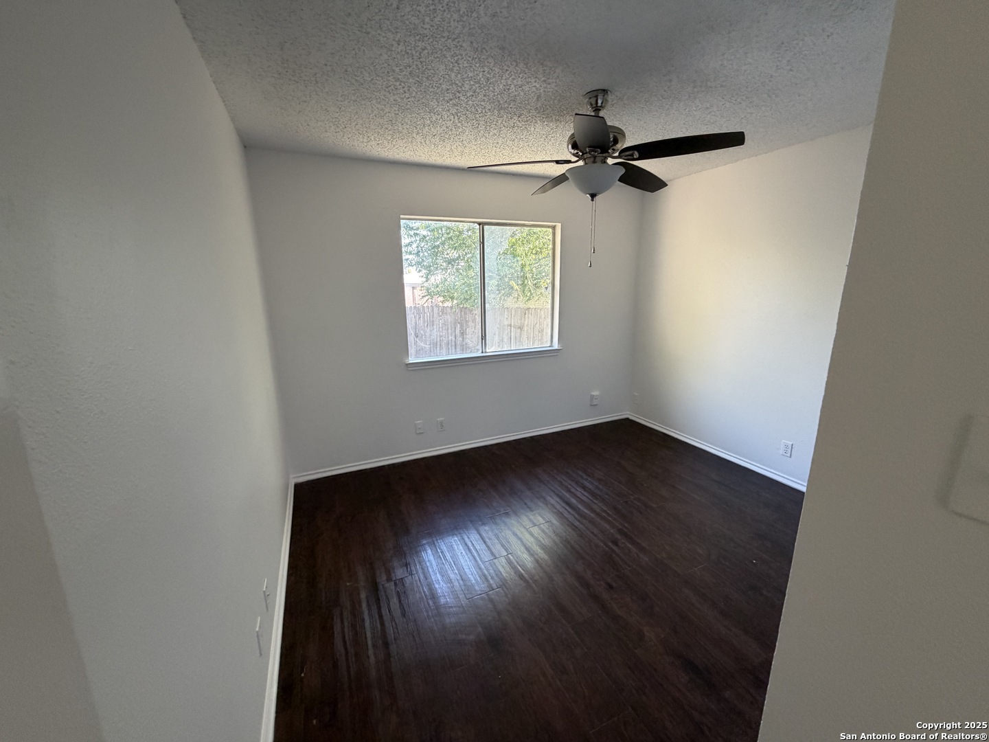 12200 Ridge Crown Street San Antonio, TX 78247 - Photo 16 of 20 an empty room with wooden floor fan and windows