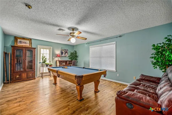 a room with wooden floor table and windows