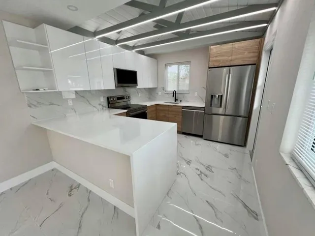 a kitchen with white cabinets and stainless steel appliances