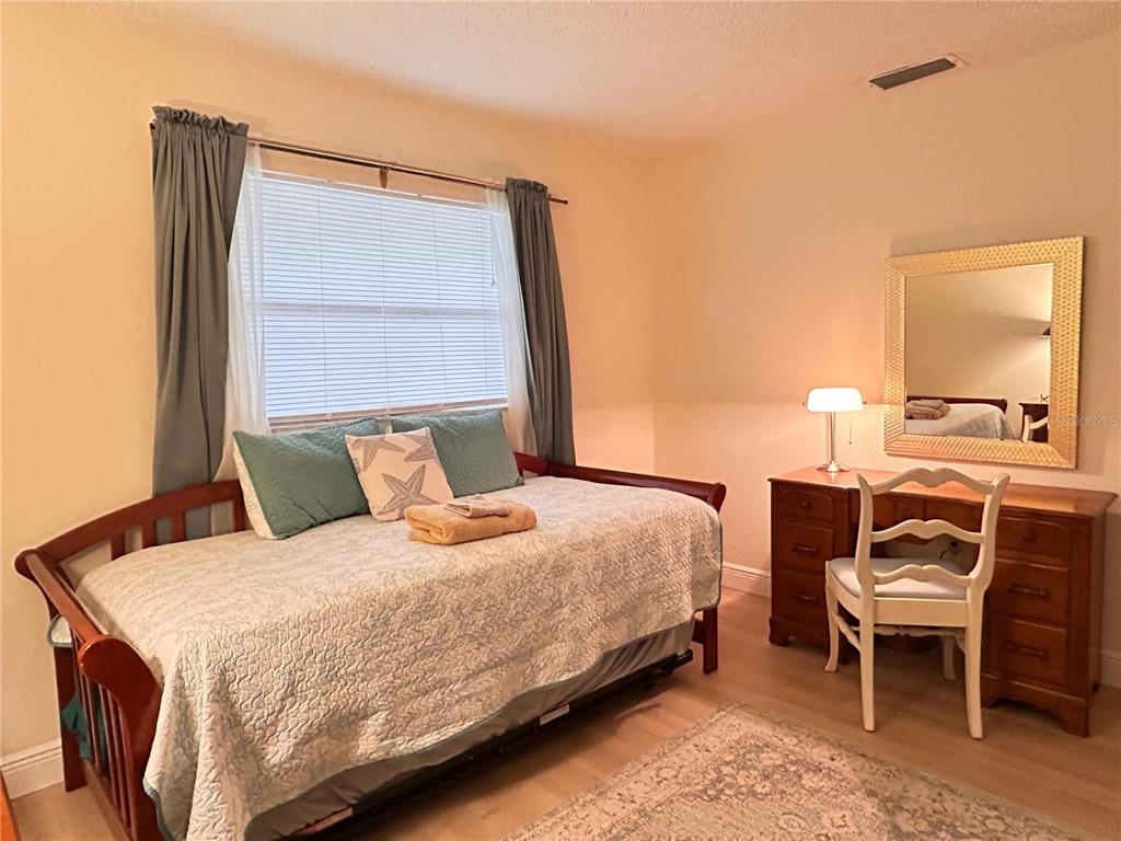 6029 Wyoming Avenue New Port Richey, FL 34653 - Photo 11 of 14 a bedroom with a bed and a table in it