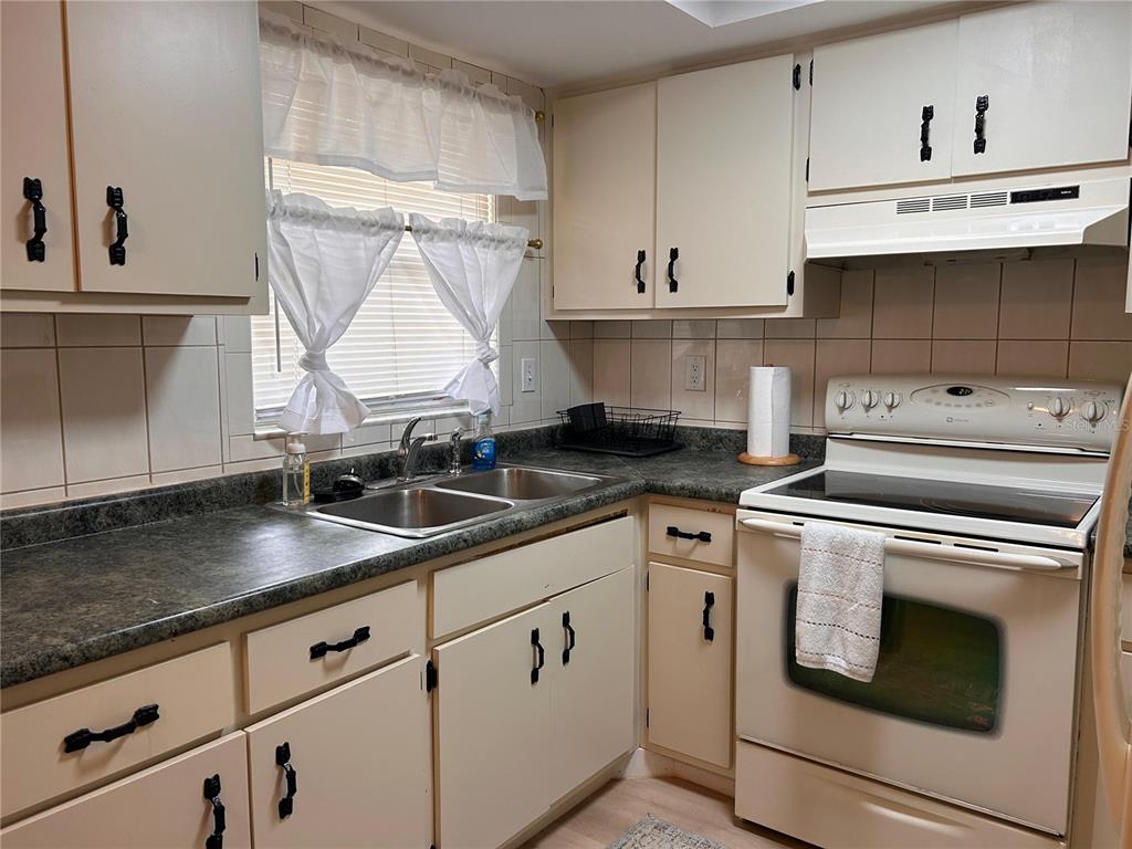 6029 Wyoming Avenue New Port Richey, FL 34653 - Photo 6 of 14 a kitchen with white cabinets and white appliances
