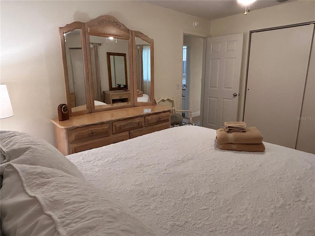 6029 Wyoming Avenue New Port Richey, FL 34653 - Photo 9 of 14 a bedroom with a large bed and a mirror