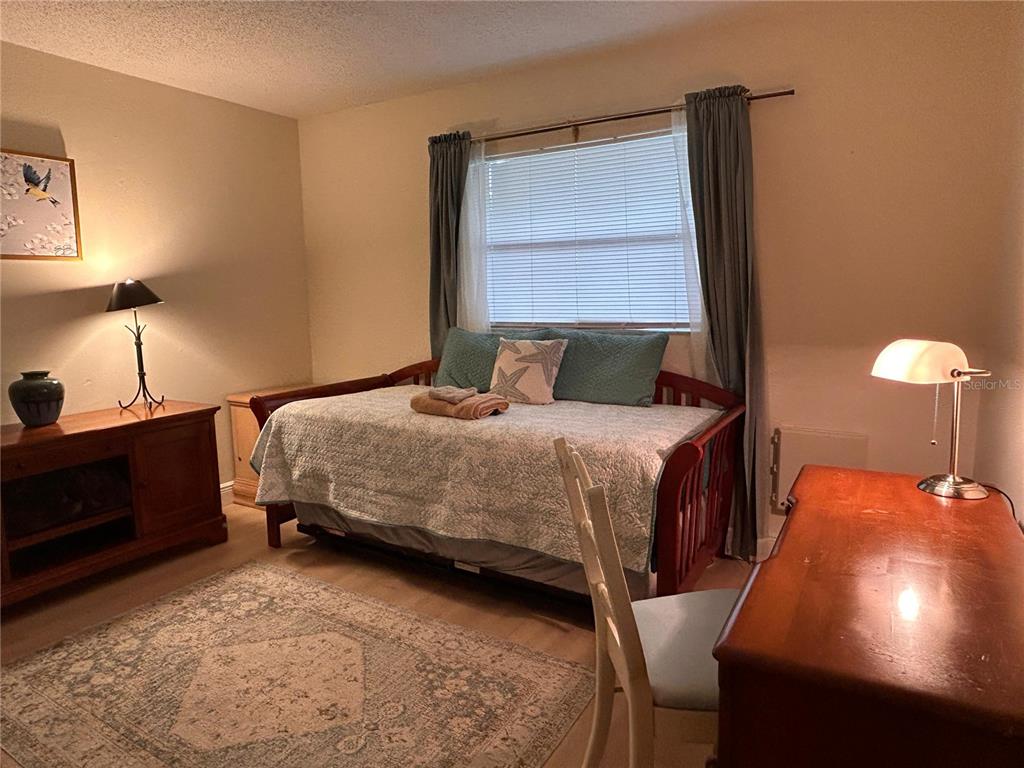 6029 Wyoming Avenue New Port Richey, FL 34653 - Photo 10 of 14 a bedroom with a bed and a lamp