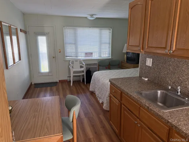 a kitchen with a sink granite top and wooden floor