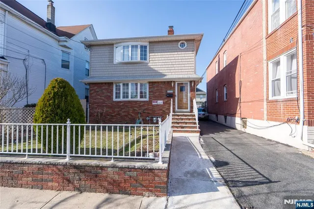 a view of a house with a small yard and wooden floor and fence