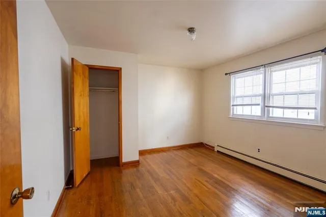 an empty room with windows and closet