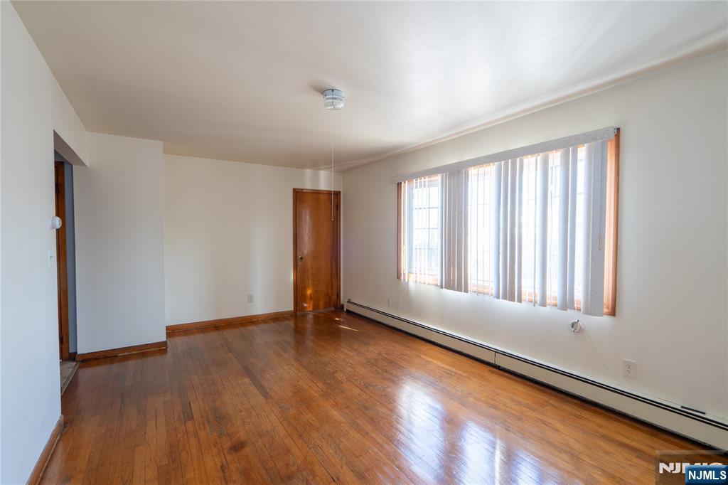 24 Mahar Avenue Clifton, NJ 07011 - Photo 4 of 20 an empty room with wooden floor and windows