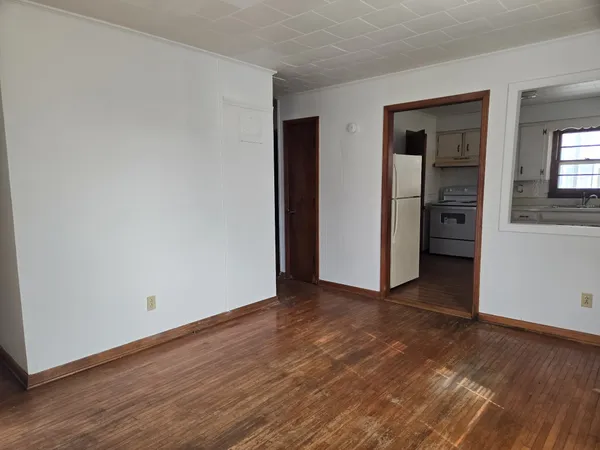 a view of an empty room with closet and a window