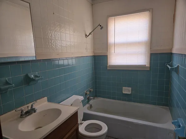 a bathroom with a sink a bathtub and a window