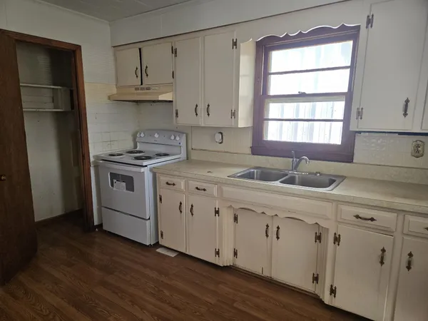 a kitchen with cabinets appliances a sink and a window